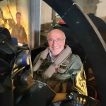 Client souriant dans le simulateur F-14 topgun de Flight Experience à Nivelles